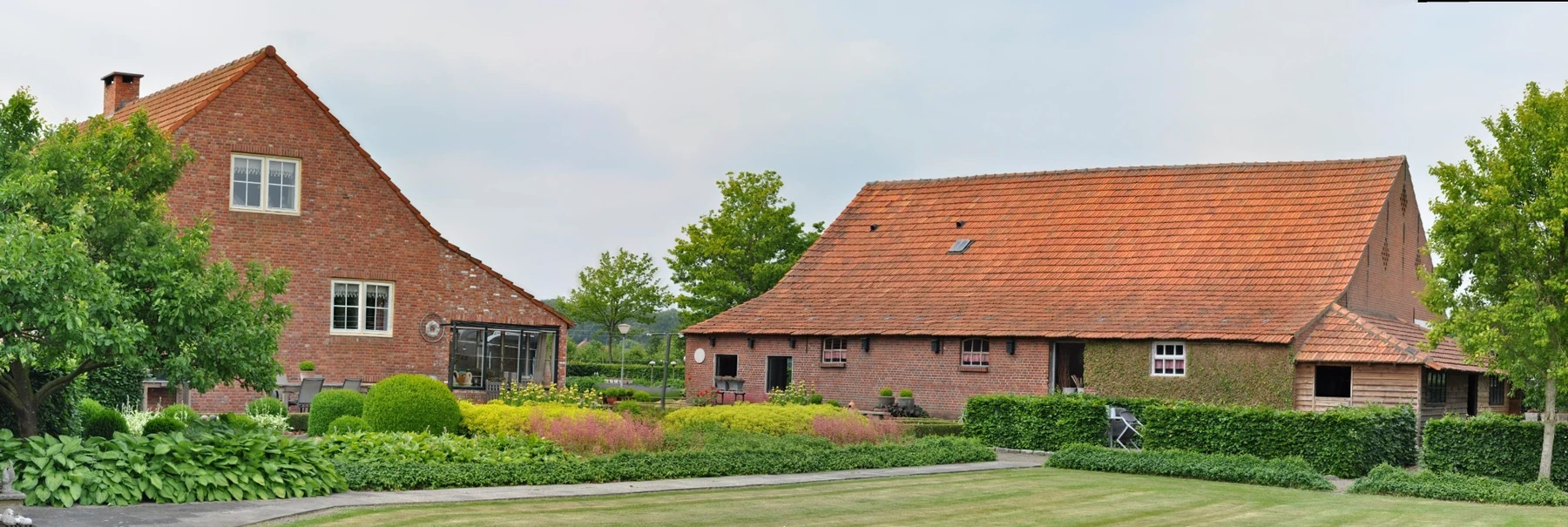 Panoramisch overzicht van Het Galders Erf met boerderij, schuren en tuin